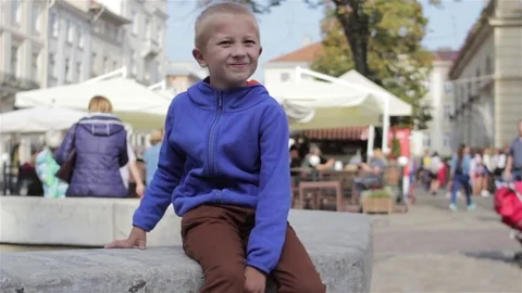 Boy is sitting in the city Stock Footage 80709669