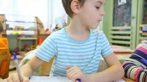 Boy sitting in classroom and watching to left Stock Footage 536341