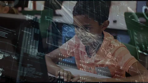 Boy sitting at computer in lab, holographic maps panels fading in, typing code Stock Footage 316186183