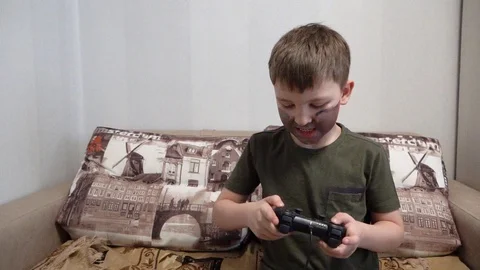 The boy sitting on the couch at home in the hands of the joystick Video stock 127160044