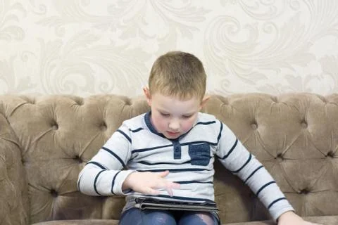 Boy sitting on the couch Stock Photos