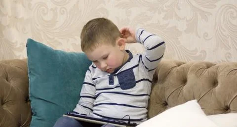 Boy sitting on the couch Stock Photos