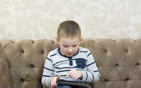 Boy sitting on the couch Stock Photos