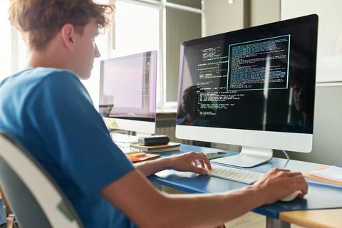 Boy Sitting at Desk with Computer Typing Code IT Class in School Stockfoto's