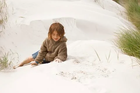Boy sitting in the dunes Fotos de archivo