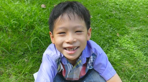 Boy Sitting In A Field Smiling  ,Slow Motion Stock Footage 52882100