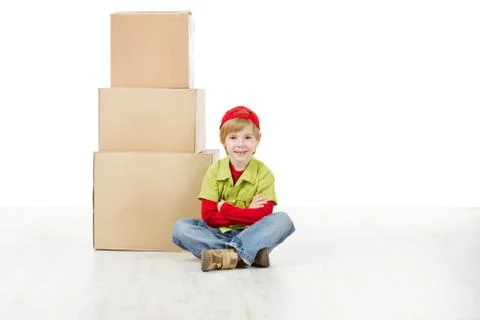 Boy sitting in front of carton boxes pyramid. Packing up to move Stock Photos