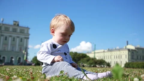 The boy is sitting on the grass laughing Stock-Footage 134734951