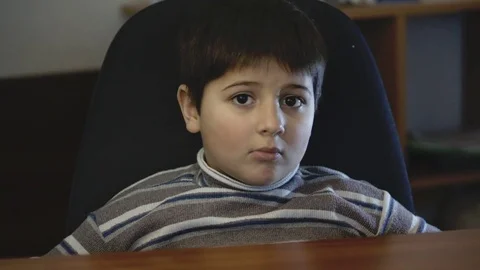 The boy is sitting at his desk Stock Footage 75558001
