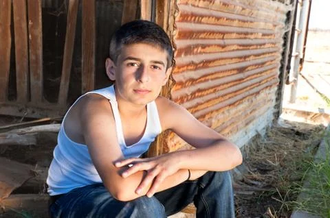 Boy sitting in old barn Stock Photos