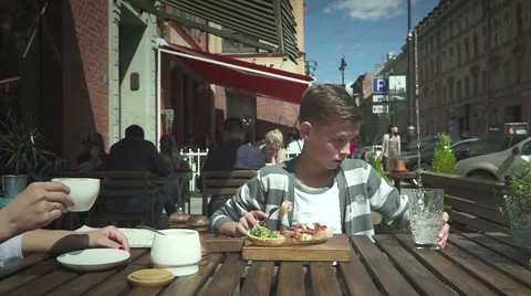 Boy Sitting In Outdoor Cafe Video stock 64897516