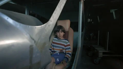 Boy sitting in plane carcass Stock Footage 207838148