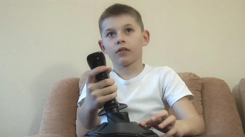 Boy sitting playing on the computer with a joystick. Expressing emotions Video stock 48333058