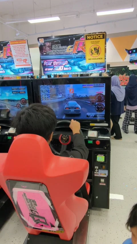 A boy sitting in a red chair playing car racing on a game console. Stock Footage 296315401