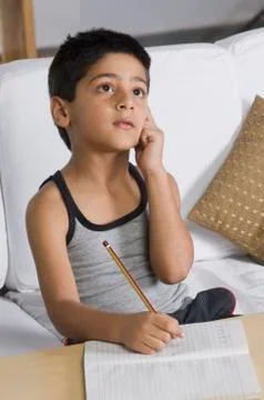 Boy sitting on a sofa and thinking 写真素材