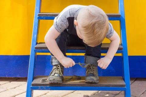 Boy is sitting on the stairs Stock Photos