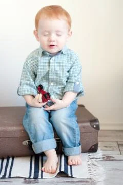 The boy is sitting on a suitcase Stock Photos