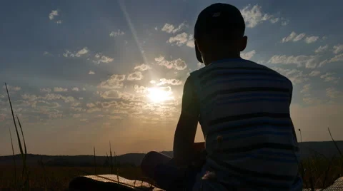 Boy Sitting on the Sunset and Thinking Stock Footage 67263096
