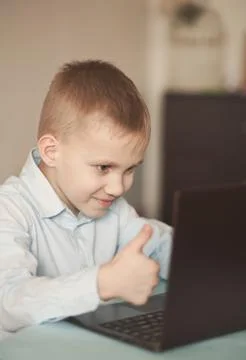 Boy sitting on the table and talking online. Workspace office desk with lapto Stock Photos