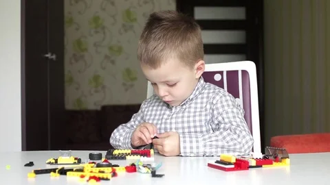 A boy sitting at the table with blocks Stock Footage 74052451