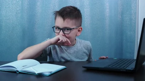 The boy sitting at the table dancing with joy. study at home Stock Footage 144683609