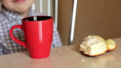 A boy sitting at the table drinkink tea Stock Footage 74053494
