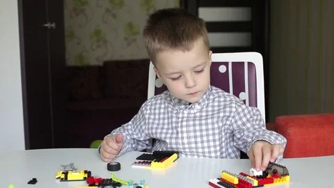 A boy sitting at the table playing with blocks Stock Footage 74052557