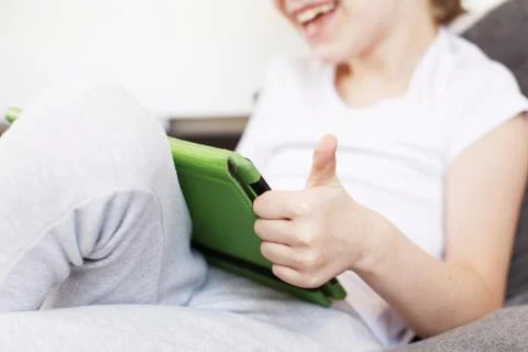 Boy sitting with a tablet on bed.Distance learning online education. Child wi Фото