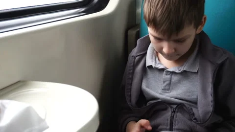 Boy of six years playing on a smartphone while sitting in a train. Stock Footage 149010219