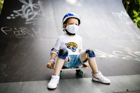 A boy with a skate in a mask, learning to skate, in full protection in Stock Photos