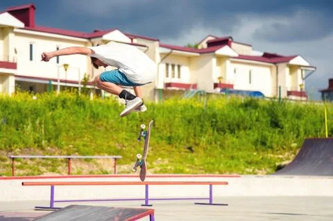 A boy in a skate park doing a trick on a skateboard Stock Photos