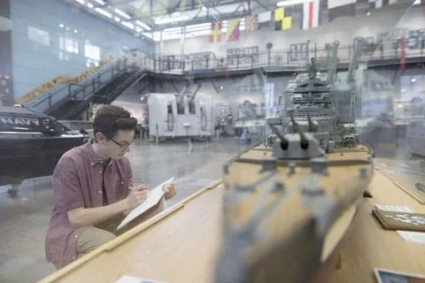 Boy sketching model Naval ship exhibit in war museum Foto stock