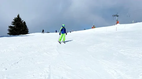 Boy ski downhill to camera on skiing track at alpine resort Stock Footage 211398401