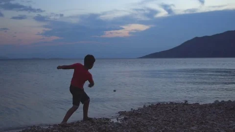 Boy Skipping Stone By The Sea Stock Footage 84129947