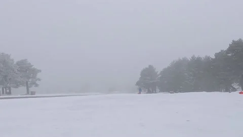 Boy with a sled going up a toboggan run under an snow storm Video stock 201690834