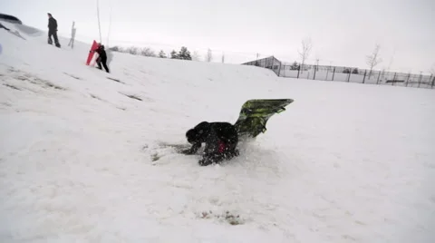Boy sledding off jump slomo Stock Footage 45021256