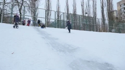 Boy in sledge down a snowy slope. Slow motion 01.10.2020 Ukraine, Kiev Stock Footage 126642846
