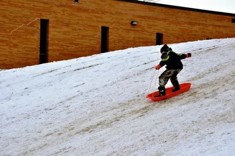 Boy sleds standing up Фото