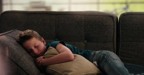 Boy sleeping on the couch holding a pillow Stock Footage 78856452