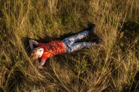 The boy sleeping in the field on the grass, Foto stock