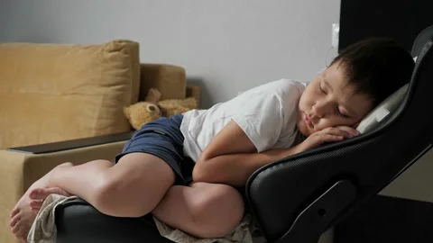 Boy sleeping sweetly on a computer chair Stock Footage 156890120