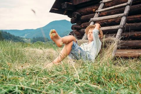 Boy sleeps in hay under the old barn Foto stock