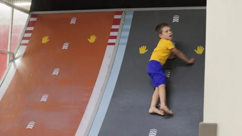 Boy slide down the walll in playroom. Stock Footage 264765292