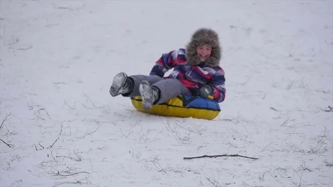 Boy slides down the mountain in the snow Stock Footage 71692997