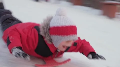 The boy slides down the winter slide. Riding at Christmas. Video stock 240340777