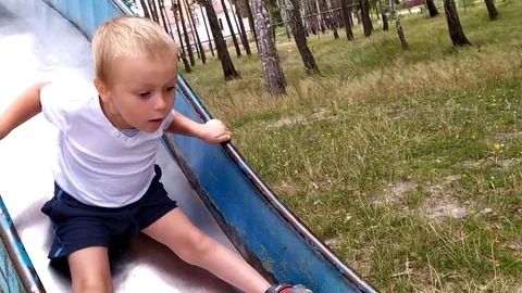 The boy slides downhill an unusual angle Stock Footage 115320749