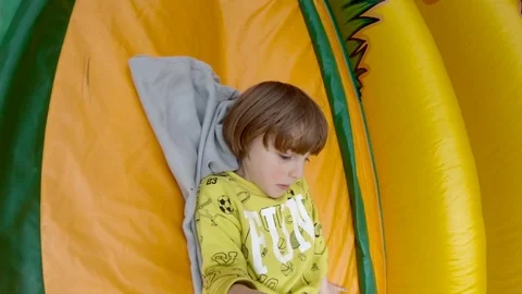 Boy sliding on Bouncy Castle Stock Footage 113456657