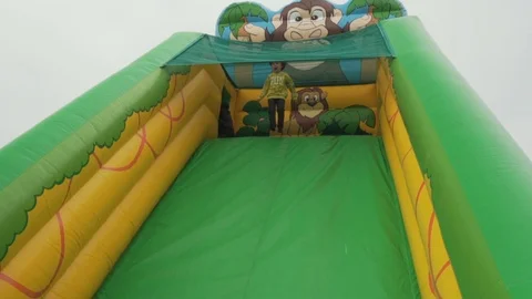 Boy sliding on Bouncy Castle slide Stock Footage 113456899