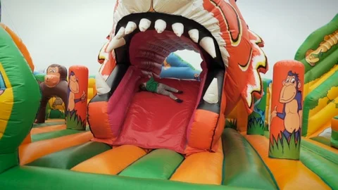 Boy sliding on Bouncy Castle slide Stock Footage 113457007