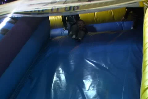 Boy Sliding Down Big Inflatable Slide Stock Footage 10710128